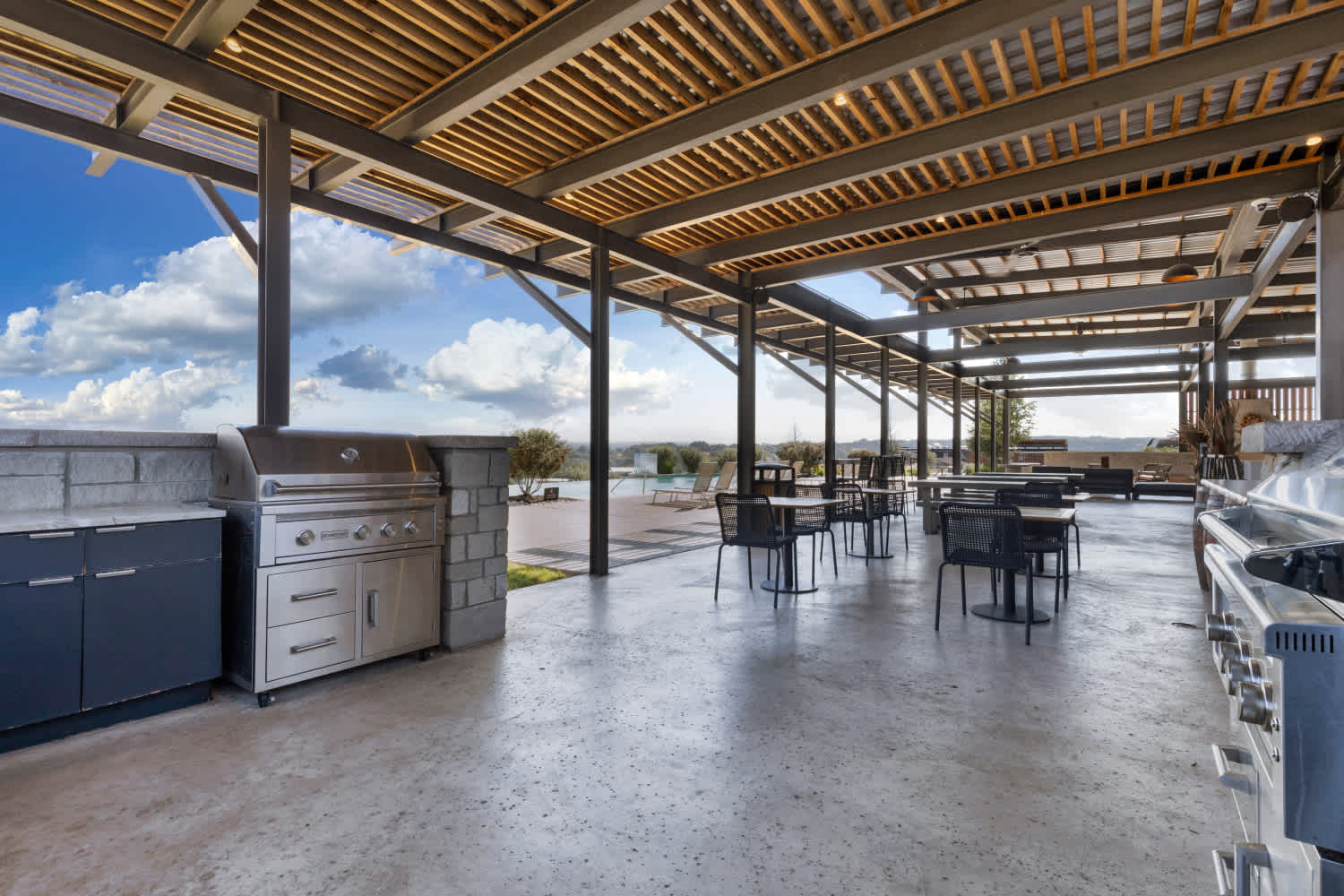 Outdoor kitchen with grills and dining tables