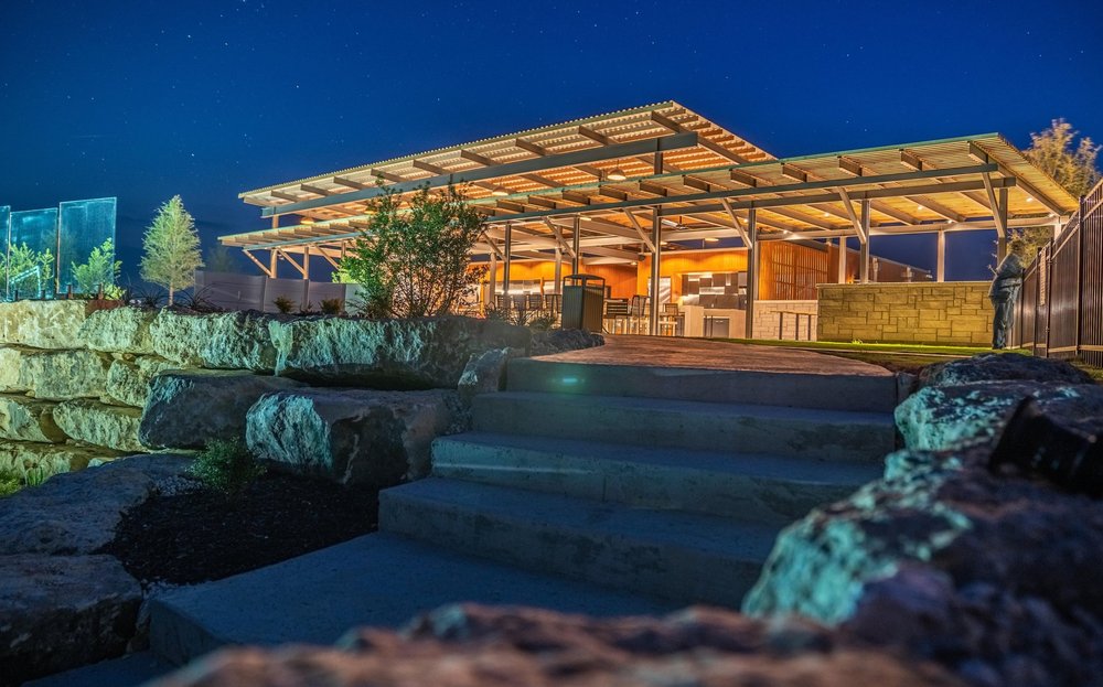 The resort pavilion lit up at night above boulder steps