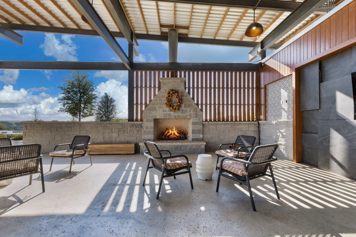 Stone fireplace and lounge seating under the covered pavilion